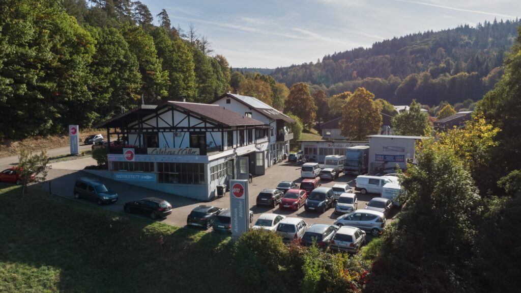 Autohaus Müller-Wolpert mit Werkstatthof und bewaldeter Umgebung